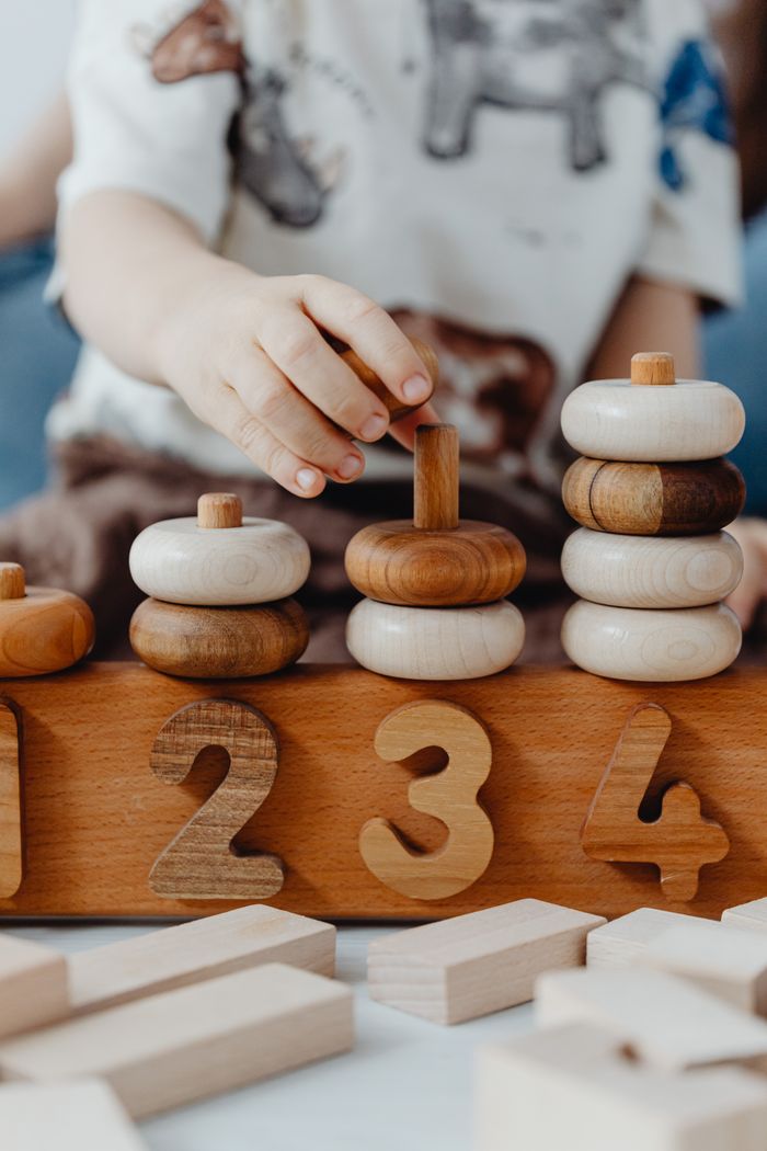 services-03 A child interacts with educational wooden number blocks, enhancing cognitive skills.