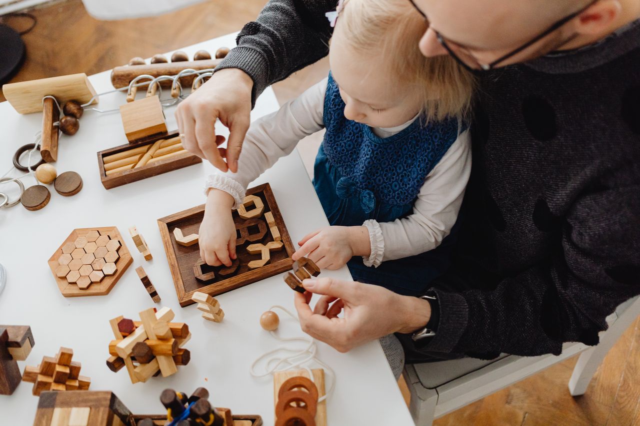 services-01 Father and daughter playing with wooden educational toys, fostering bonding and development.